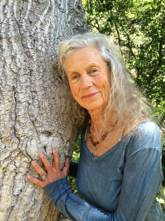 Angela pictured next to the trunk of a large tree